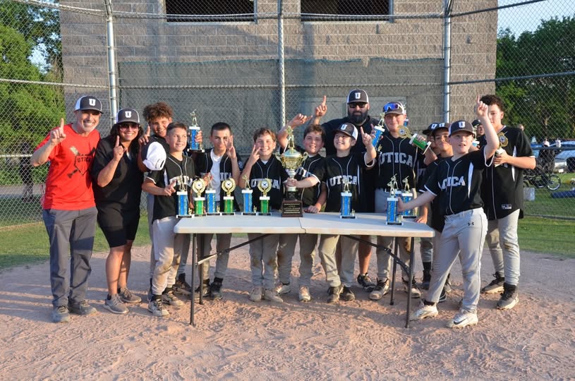 Parkway Drugs Sponsored Baseball team standing around table with trophies after winning championship